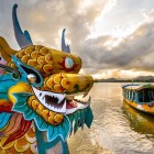 Traditional dragon boat on the river in Hué, symbol of local culture, among calm waters, historic architecture, and the imperial Vietnamese atmosphere.