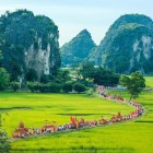 The event in Tam Cốc celebrates local culture, featuring agricultural traditions, boats on the rivers, and picturesque views among rice fields and mountains.