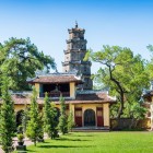 On the banks of the Perfume River, Thien Mu Pagoda in Hué dominates the landscape with imperial architecture, historic towers, and stunning river views.
