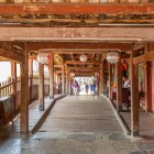 Inside Hoi An’s Japanese Covered Bridge, suspended lanterns captivate, highlighting architectural details and the charm of the historic center.
