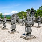 Statues of warriors at King Khai Dinh’s Tomb in Hué guard the entrance, amid detailed mosaics and the lavish architecture of the Nguyen dynasty.