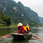 A boat tour in Tam Cốc navigates calm rivers among rice fields and karst mountains, offering picturesque views of Vietnam’s natural beauty.