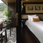 The Deluxe cabin on the Victory Star Cruise offers a panoramic balcony, comfortable bed, and modern amenities to admire Halong Bay.