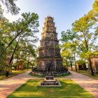 Thien Mu Pagoda in Hué rises amid lush vegetation, between historic towers and vistas of the Perfume River, a spiritual symbol of Vietnam.