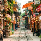 The tracks of Hanoi Train Street run between colonial houses dating back to 1902, where the train and daily life coexist among souvenirs, bicycles, and the aroma of coffee.