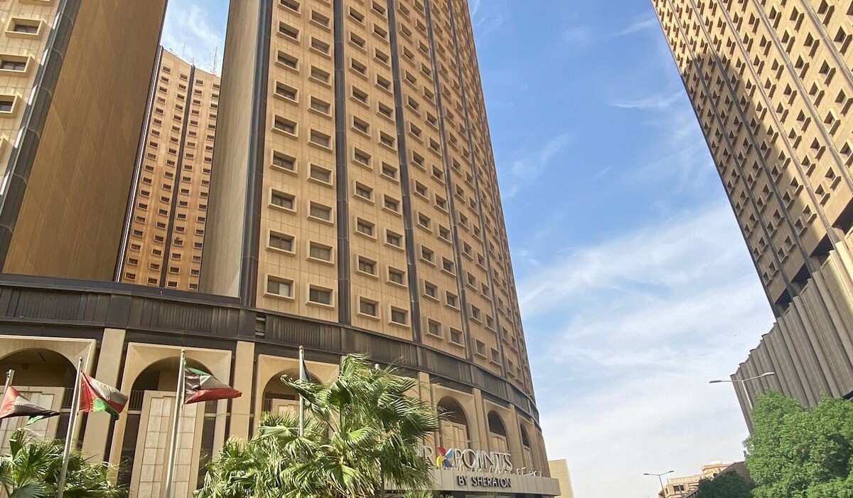 Four Points by Sheraton Riyadh Khaldia - Elegant entrance with arches and golden façade, the Four Points by Sheraton logo stands out among palm trees and glass walls for a warm, refined welcome.