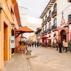 San Cristóbal de las Casas’ main street is a lively pedestrian avenue lined with colorful colonial buildings, outdoor cafés, artisan shops, and a vibrant, authentic atmosphere.