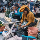 Indigenous Mexican women at the San Cristóbal de Las Casas market display fresh vegetables on colorful handmade cloths, keeping ancient traditions alive in a vibrant, authentic atmosphere.