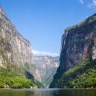Sumidero Canyon in Chiapas opens into a massive gorge, with towering vertical cliffs rising hundreds of meters above the green river. A majestic, wild landscape and a natural symbol of Mexico.