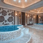 Elegant wellness area with whirlpool pools, decorative mosaics and soft lighting. A refined, relaxing setting ideal for moments of wellbeing and exclusive comfort.