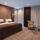 Elegant and modern double room with a king-size bed, upholstered headboard, refined furnishings and a relaxation area with armchairs. Bright, comfortable and carefully designed space.