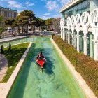 Charming urban view in Baku with an artificial canal, tourist boat and elegant architecture. A modern corner blending greenery, water and a relaxing atmosphere.