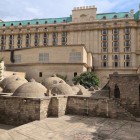 The ancient Gasim Bey Baths, with their characteristic stone domes, stand in Baku’s Old City next to the Four Seasons Hotel, blending history with contemporary luxury.