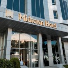 Modern exterior of Midtown Hotel in Baku with glass façade, light panels and a bright entrance. The golden sign adds elegance and a refined contemporary style.