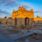 The Absheron Fire Temple in Azerbaijan features ancient stone structures and braziers fueled by natural gas, symbol of fire worship in an evocative atmosphere.