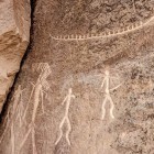 Prehistoric rock carvings on stone depict stylized human figures and animals. Ancient artistic testimonies that tell the story of the life, rituals, and culture of early civilizations.