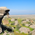 Semi-desert landscape of the Absheron Peninsula in Azerbaijan, with rocks, grasslands, and views of the Caspian Sea, a historic area rich in ancient heritage.