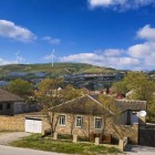 The village of Mereze in Azerbaijan features stone houses with sloped roofs and enclosed courtyards, set among green hills - typical rural Caucasus architecture.