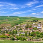 The village of Mereze in Azerbaijan lies among gentle green hills, stone houses and colorful roofs, set in a bright and authentic rural landscape.