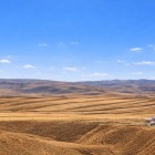 Rolling hills and golden fields stretch to the horizon under a clear sky: this is the surrounding landscape of the Diri Baba Mausoleum, symbol of Azerbaijan’s rural tranquility.