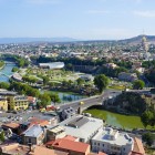 Panoramic view of Tbilisi with the Kura River, modern bridges and historic churches on the hills: a harmonious blend of ancient and contemporary architecture.