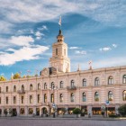 Tbilisi City Hall features elegant neoclassical lines, a symmetrical pastel façade and a clock tower overlooking the square.