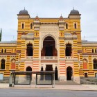 The Tbilisi Opera House blends Moorish style with Oriental influences, featuring decorated arches, elegant domes and vibrant colors with exotic charm.