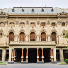 The Rustaveli Theatre features a richly decorated neoclassical façade with elegant arches and imposing columns, a cultural and architectural symbol of Tbilisi.