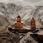 The Gergeti Trinity Church (Tsminda Sameba) overlooks the landscapes of the Greater Caucasus near the village of Gergeti, at the foot of Mount Kazbek, an iconic symbol of Georgia.