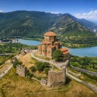 Jvari Church overlooks the Mtskheta valley where the Aragvi and Kura rivers meet: a masterpiece of Georgian architecture set among green hills and Caucasus landscapes.