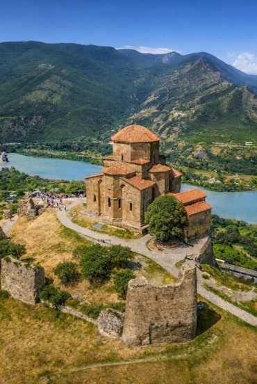 Jvari Church overlooks the Mtskheta valley where the Aragvi and Kura rivers meet: a masterpiece of Georgian architecture set among green hills and Caucasus landscapes.