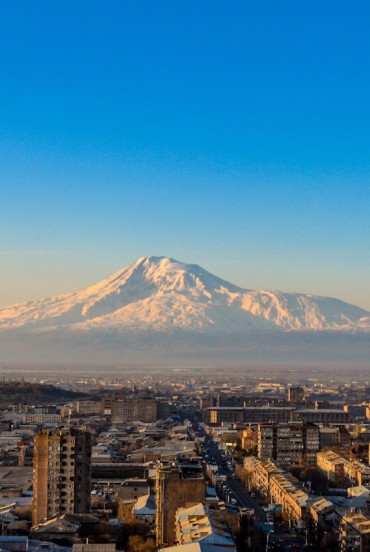 Scenic sunrise view of Mount Ararat rising majestically above the Sebastia-Malatia district of Yerevan, Armenia, as the first morning light gently illuminates the city.
