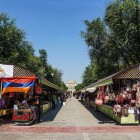 Vernissage Market in Yerevan with stalls of handmade souvenirs, textiles and traditional items, full of vibrant colors and authentic atmosphere under the summer sky.