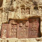 Khachkars carved into rock at Geghard Monastery in Armenia: ancient cross-stones symbolizing faith and art, among the most fascinating expressions of Armenian heritage.
