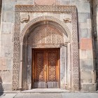 Decorated entrance portal of Geghard Monastery in Armenia, rich in carvings and medieval details: a remarkable example of sacred art among the Caucasus’ iconic UNESCO sites.