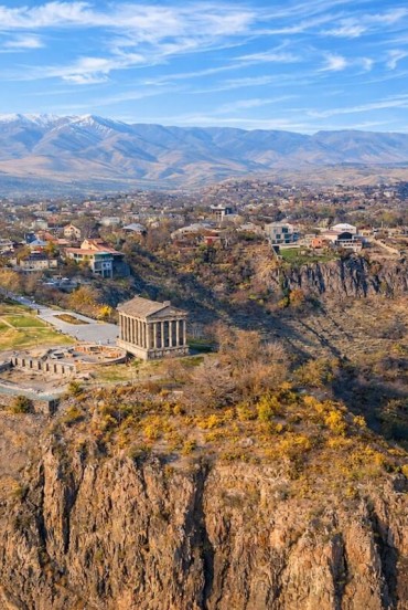 Aerial view of the Garni Temple in Armenia, perched above the Azat Gorge, surrounded by mountains and villages: one of the most iconic and scenic historical sites in the Caucasus.