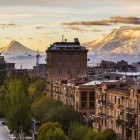 Vista panoramica di Yerevan con il Monte Ararat sullo sfondo. All’alba la città si illumina in calde tonalità seppia, creando un suggestivo effetto vintage.