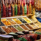 Traditional market stall in Kutaisi with dried fruits and colorful churchkhela. Authentic Georgian flavors enhanced by warm light and lively atmosphere.