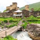 View of Ushguli at the foot of Mount Shkhara, with stone towers and ancient houses. A picturesque Svaneti village set in stunning mountain scenery.