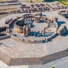 Aerial view of the ruins of Zvartnots Cathedral in Armenia, a UNESCO site with a circular structure and stone columns set in a historic landscape