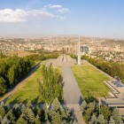View of the Tsitsernakaberd memorial in Yerevan, symbol of the Armenian Genocide, set in a park with tree-lined avenues and panoramic city views.