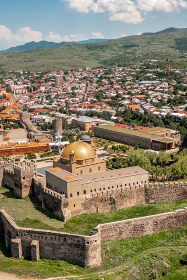 Panoramic view of Akhaltsikhe with Rabati Fortress, medieval walls, towers and golden domes, set among green hills and the authentic landscape of Georgia.