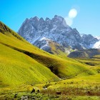 A bright green valley at the foot of Mount Chaukhebi, where winding trails cross alpine pastures and lead toward the spectacular peaks of the Georgian Caucasus.