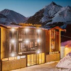 View of Gudauri Inn, a modern mountain resort surrounded by the peaks of the Greater Caucasus, ideal for outdoor stays in every season.