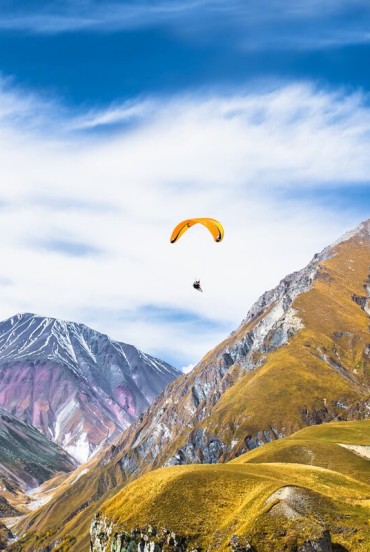 Paragliding above the peaks of Gudauri, offering a unique perspective over the Caucasus mountains and the wide-open landscapes of highland Georgia.