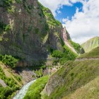 Scenic stretch of Truso Gorge, where the trail follows the river between towering rock walls and green slopes in the heart of the Georgian Caucasus.