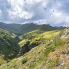 Trail through the green valleys of Gergeti toward Sabertse Pass, a scenic trek crossing open and peaceful landscapes in the heart of the Caucasus.