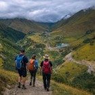 Hikers descending the trail toward Kvesheti, through open valleys and Caucasus mountains accompanying the route toward the Georgian valley floor.