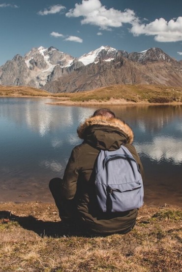 On the shores of Koruldi Lake, among clear reflections and silence, the view drifts towards the Caucasus mountains in a timeless landscape.