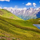 Koruldi Lake at 2,740 meters, among green meadows and gentle slopes. A simple landscape where water reflects the silence and vastness of Svaneti.